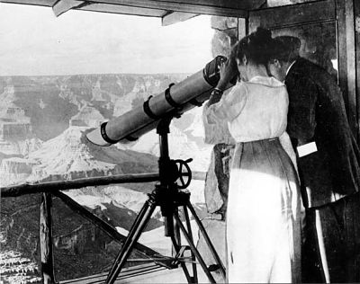 two people looking into a very large telescope