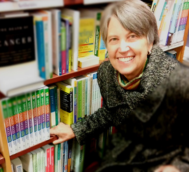 christine a padesky phd in 2015 in a bookstore in front of a shelf of mind over mood second edition books