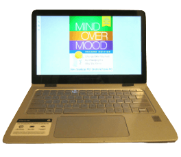 a laptop computer showing the cover of mind over mood second edition book