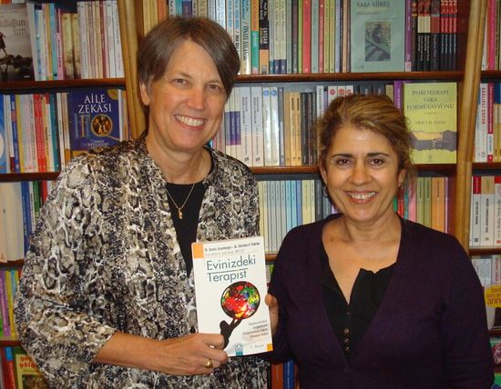 photo of christine a padesky phd holding the turkish translation of the first edition of mind over mood standing beside dr emel stroup the primary translator